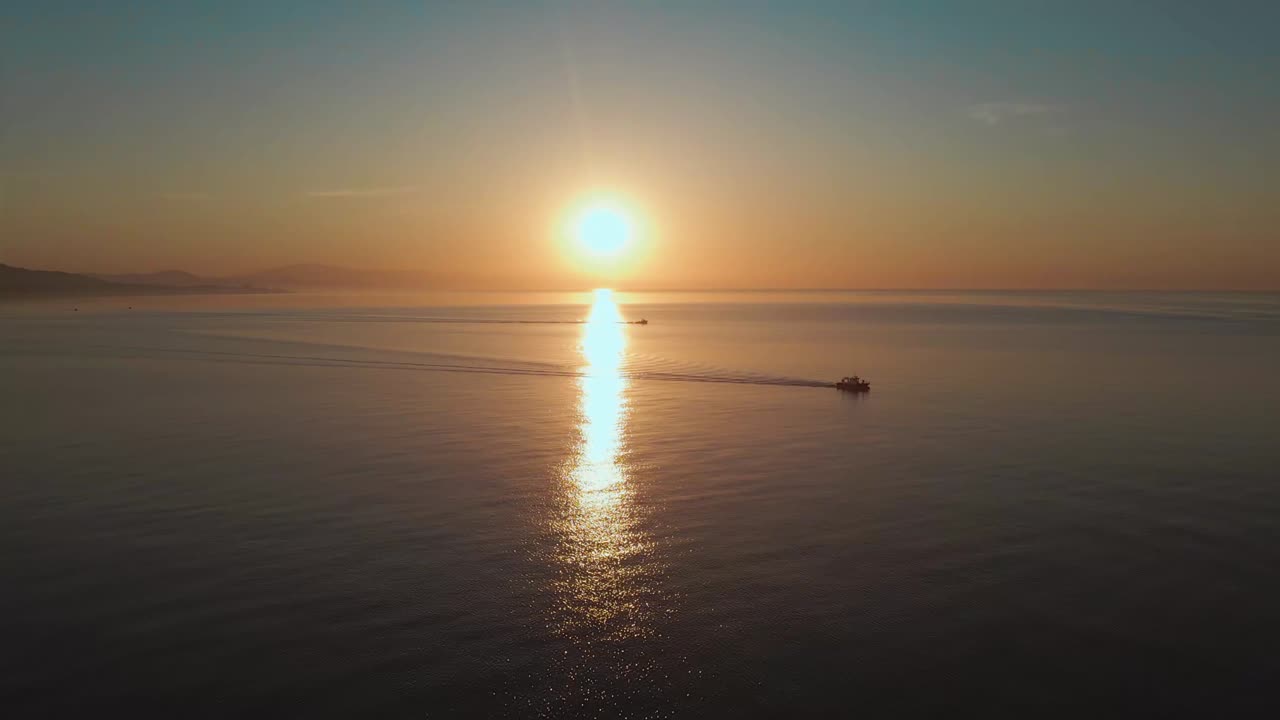 motorboats during serene fire sunset in Fuengirola, Malaga, Spain.