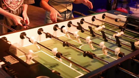 two players engaged in intense foosball match