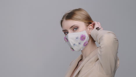 portrait of woman in face mask with flowers posing