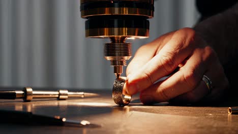 jeweler working on a ring with a precision machine