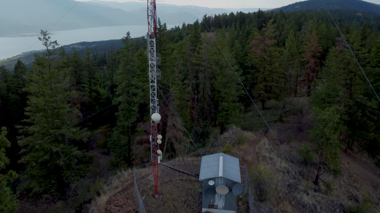 drone volando hasta el transmisor de la torre celular de comunicaciones de radio en una montaña remota