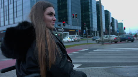 a handicapped woman sitting in a wheelchair waiting on the zebra cross side