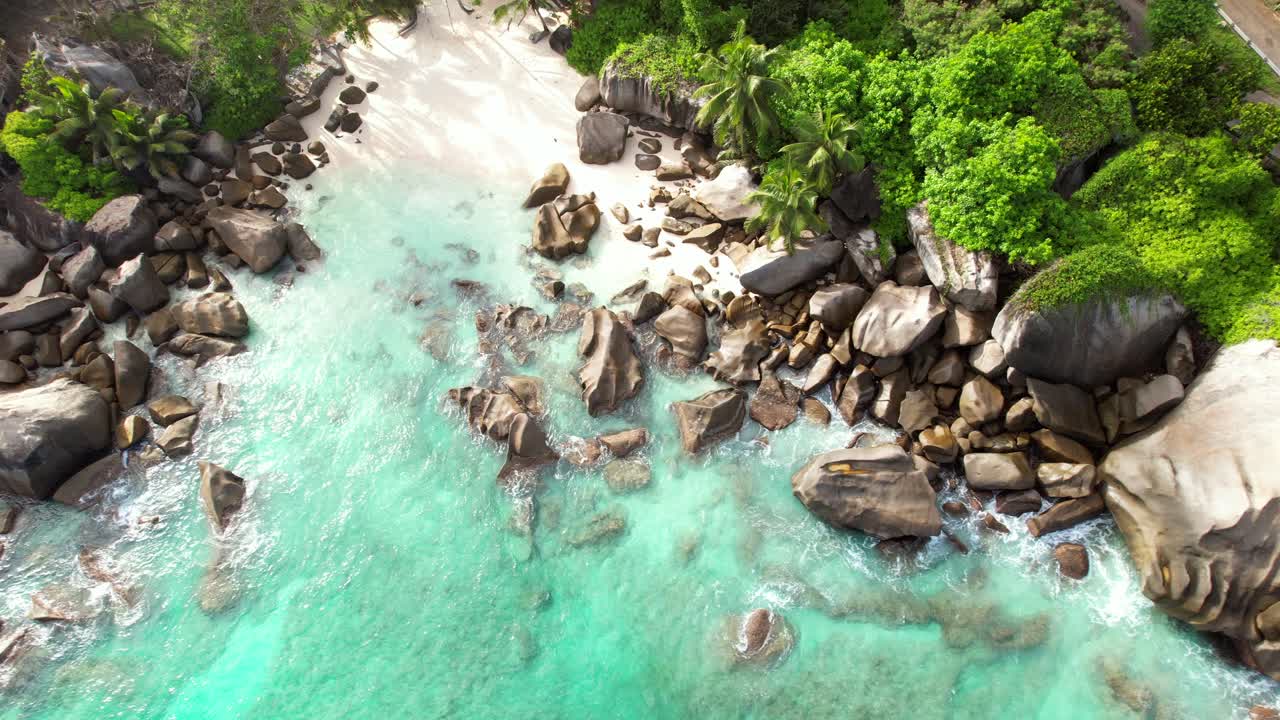 tomada de avión no tripulado de la playa oculta cerca de la playa de north east point, enormes rocas, playa de arena blanca y agua turquesa, mahe seychelles 30 fps