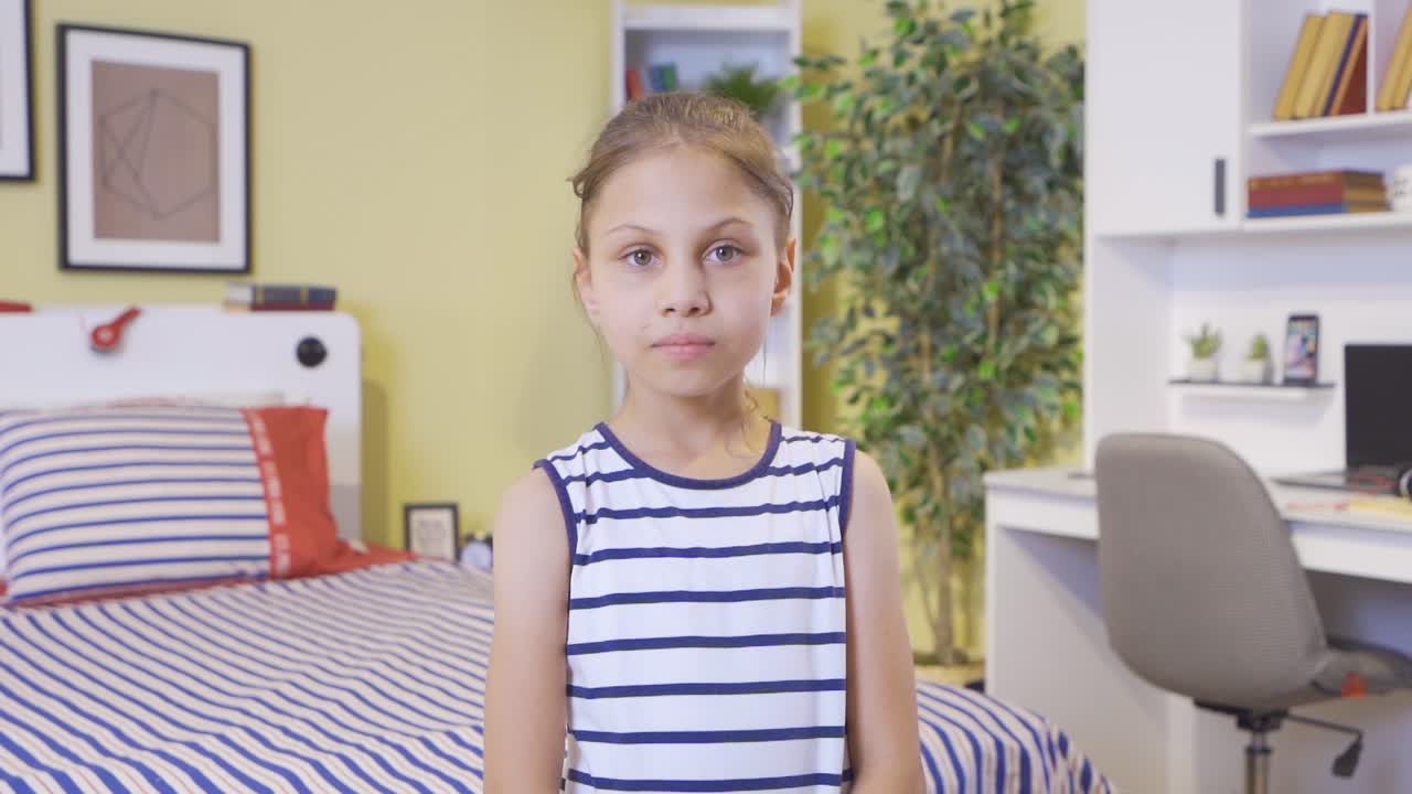 Girl looking at camera and smiling in her room.