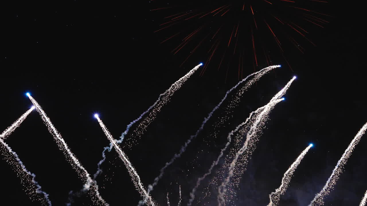 Vivid fireworks explosions filling the night sky with intense color