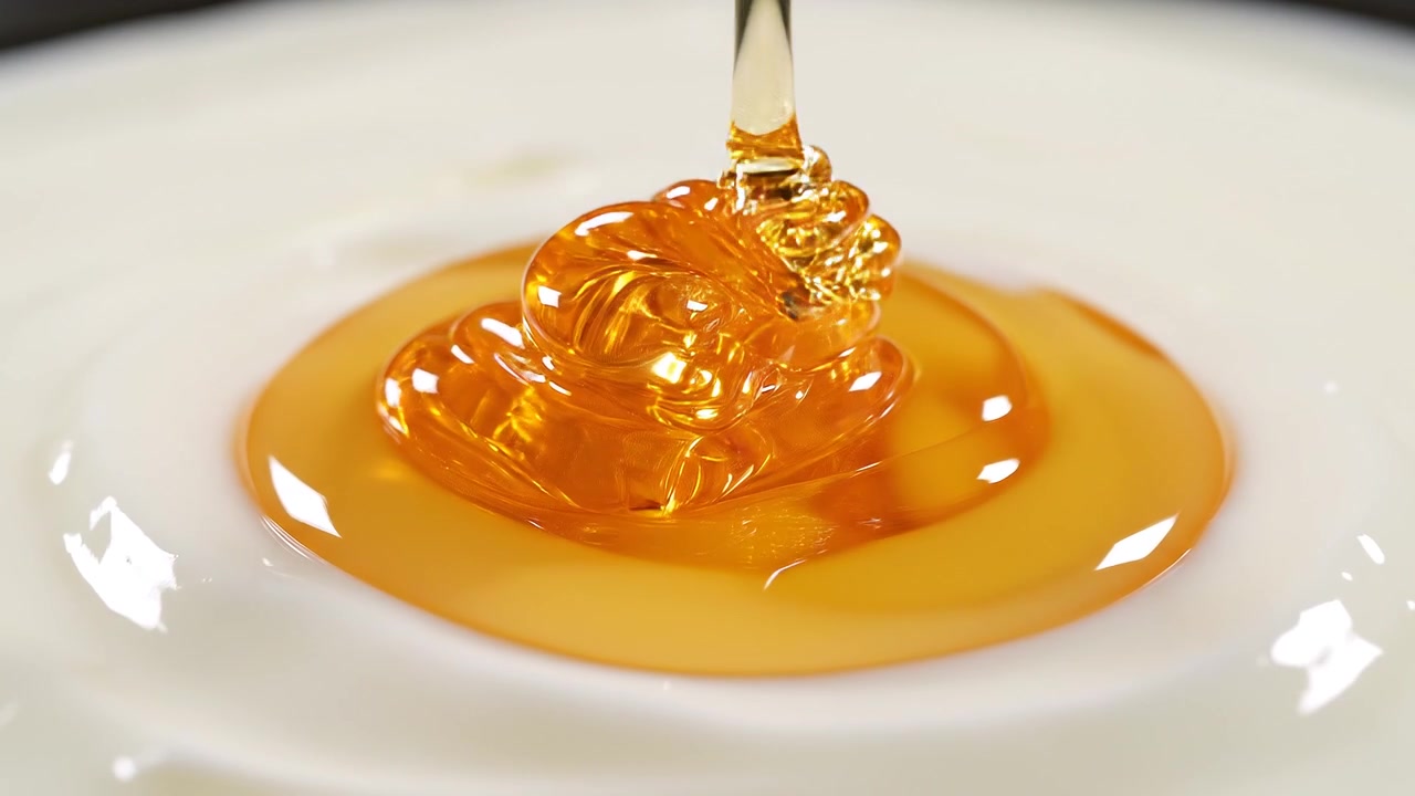 クリーミーな白いヨーグルトに注がれる黄金色の蜂蜜。