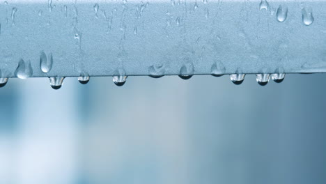 raindrops falling from metal cross beam