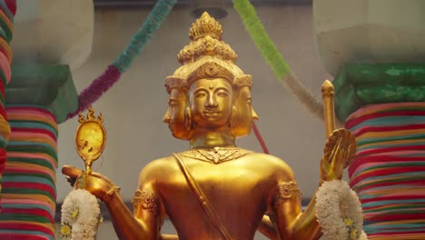 smoke from burning incense in front of four-faced god statue, brahma at temple