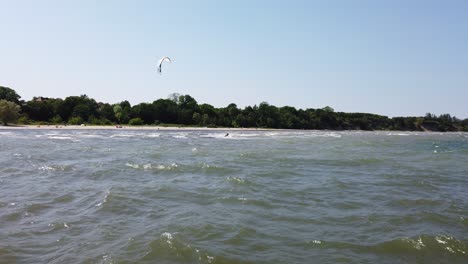 Surfista-De-Cometas-Se-Desliza-Sobre-El-Agua-Cerca-De-La-Playa