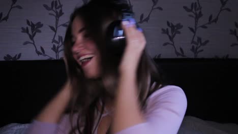 happy teenage girl dancing in her room with headphones listening to music