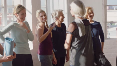 yoga class of happy old women chatting enjoying healthy fitness lifestyle sharing conversation in wellness workout studio