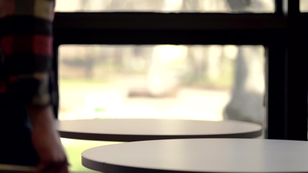 체크무늬 플란넬 셔츠를 입은 젊은 남자가 딱딱한 공책에 노트를 적고 있다 - 클로즈업 샷