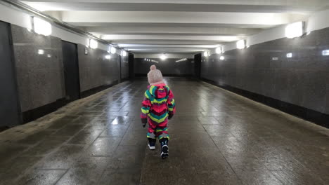 little independent kid walking alone in undeground walkway