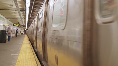 Train-Arrives-in-NYC-Subway-Station,-doors-open,-woman-boards-the-train