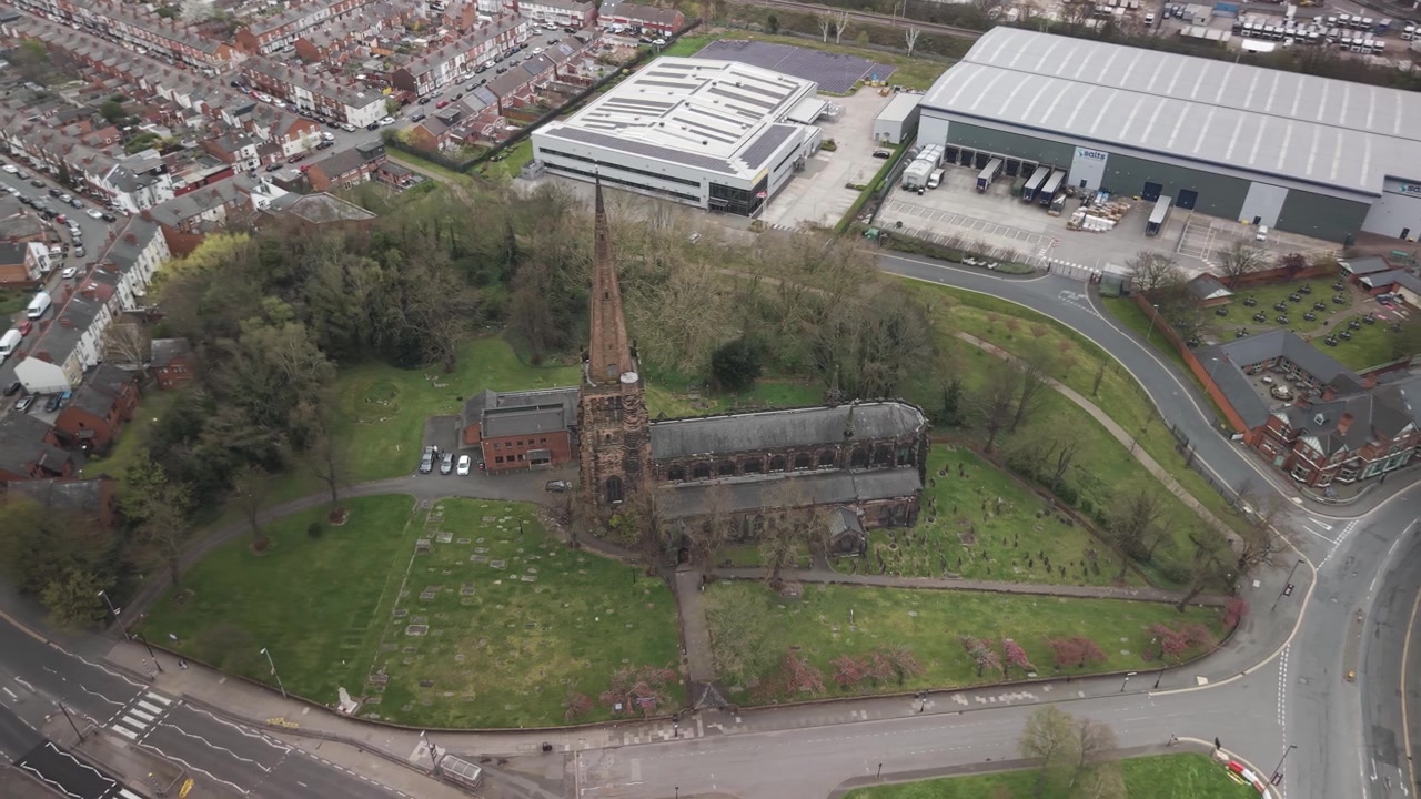 Aerial view of Aston Parish Church in Birmingham with roads, trees and nearby buildings around it.