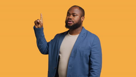 salesman pointing upwards with finger doing recommendation, studio background