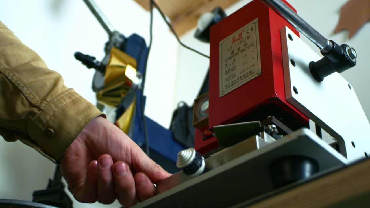 artesano que trabaja con la prensa de sellos de libra. impresión de sellos en material de cuero