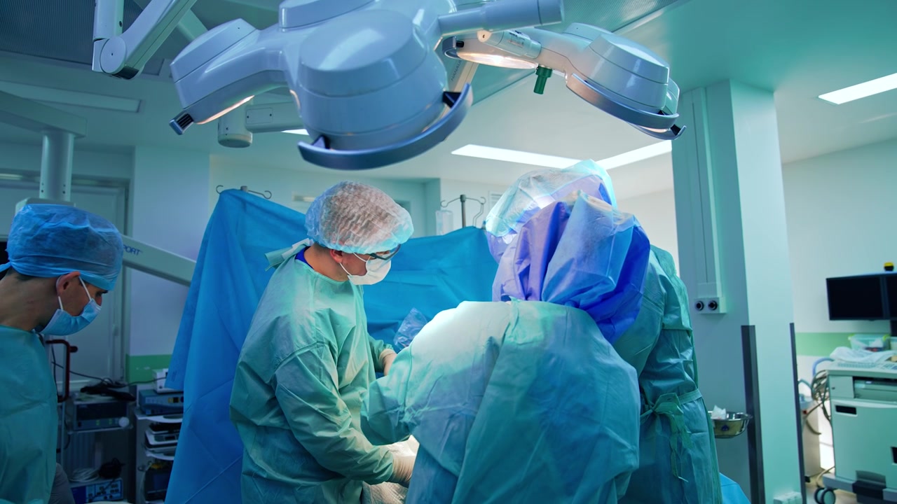 Surgical team operating the traumatized leg. Professional orthopedic doctors cooperate in modern surgery room.