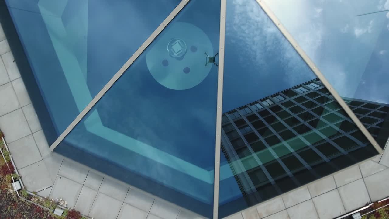 avión no tripulado volador y edificio de oficinas reflejado en la ventana de la claraboya