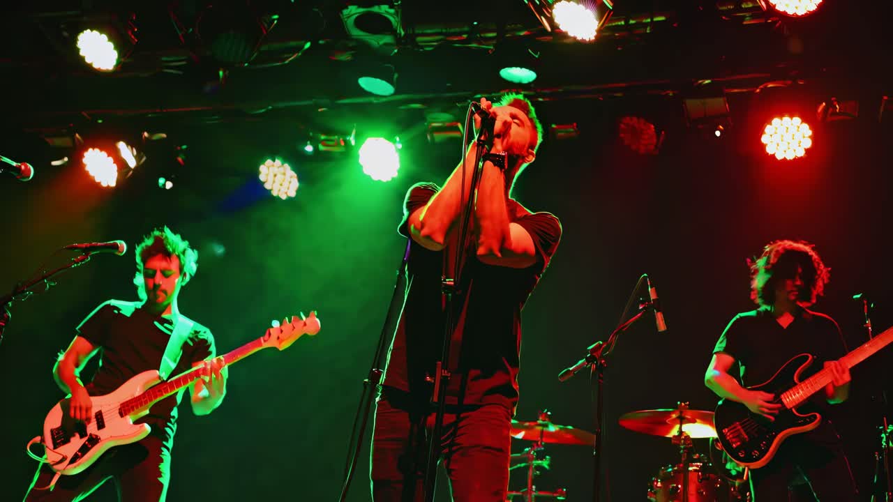 Dynamic low-angle shot of a rock band performing on stage with vibrant lighting