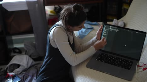 mujer limpiando la computadora portátil en casa