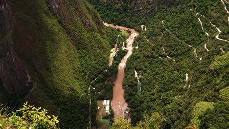 machu picchu seen from top of high altitude mountain huayna picchu, ancient inca empire with steep road in peru, panning down to house with football field for reference