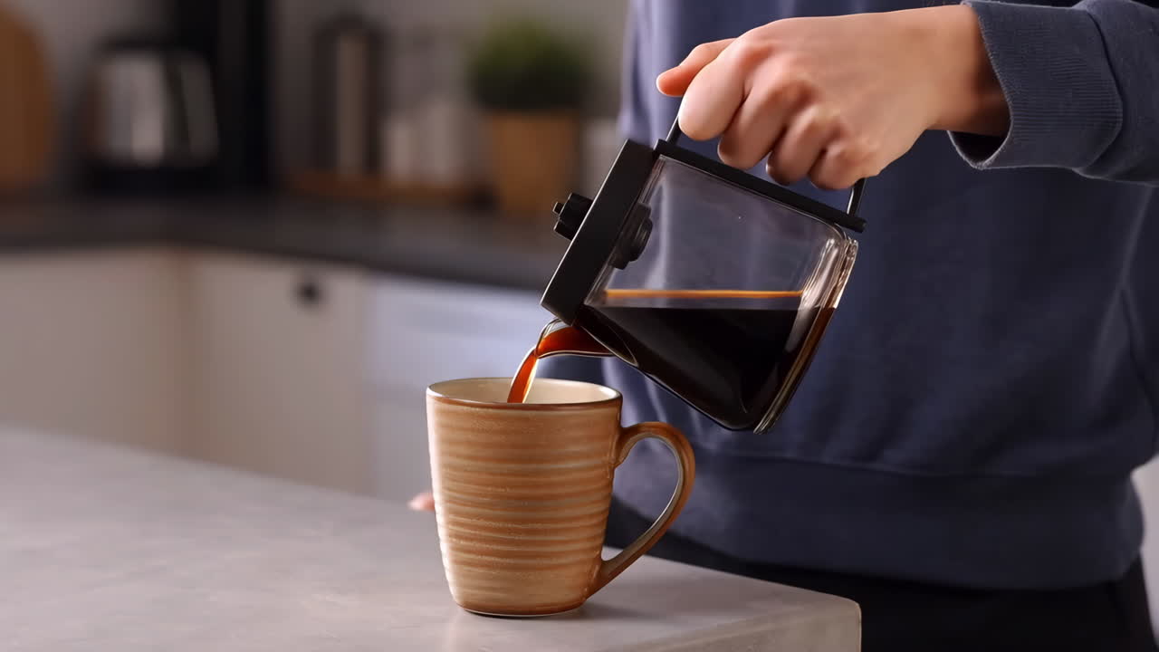 Pouring Fresh Coffee into a Mug in the Kitchen