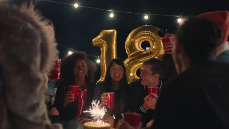 happy group of friends celebrating birthday party on rooftop at night making toast to friendship posing for photo having fun sharing celebration