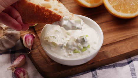 dipping bread in tzatziki sauce