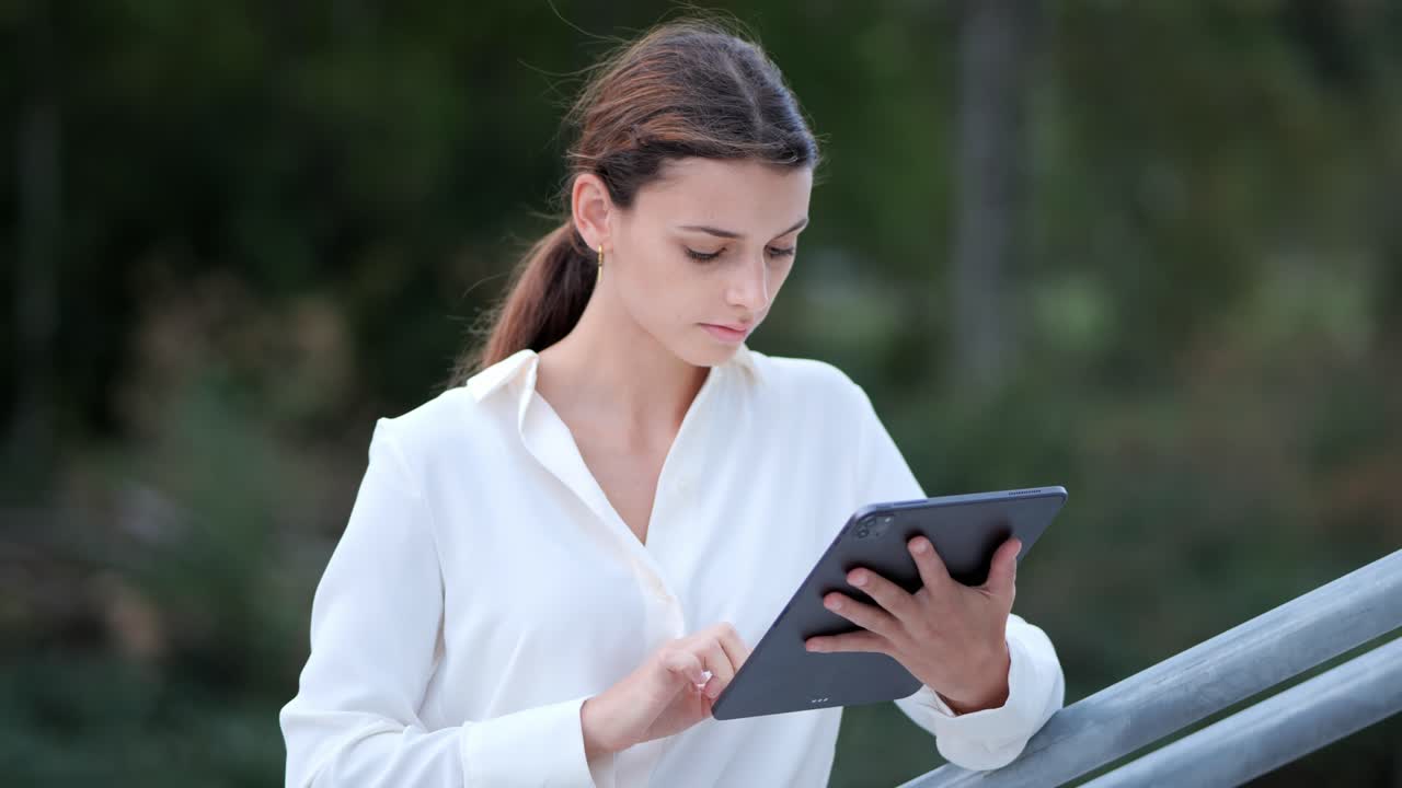 Medium shot of a businesswoman&acute;s face while typing something on her tablet