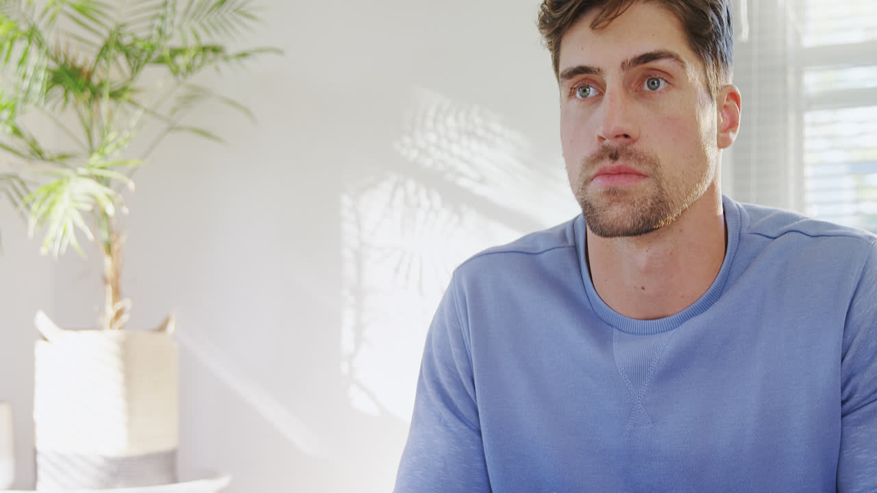 Giovane uomo serio che guarda la televisione a casa 4K 4k