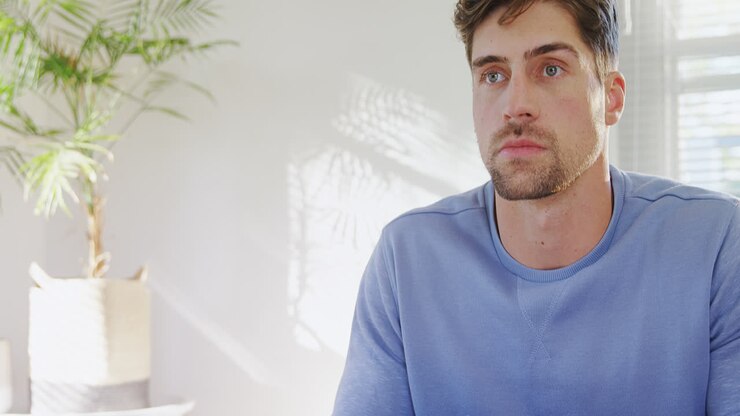 Giovane uomo serio che guarda la televisione a casa 4K 4k