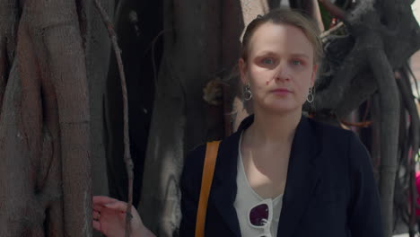 portrait of a woman standing by tree roots