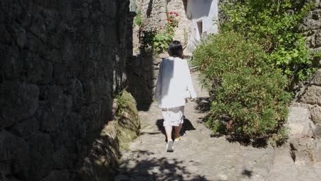 Rückansicht-Einer-Nicht-Wiederzuerkennenden-Frau,-Die-In-Der-Gasse-Des-Historischen-Zentrums-Von-Monsanto,-Portugal,-Spaziert