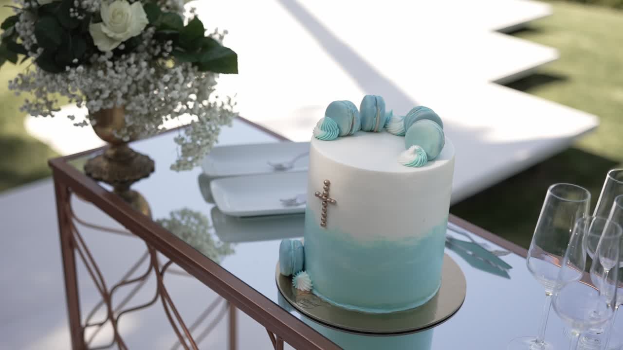 elegante tarta con macarons y flores expuesta sobre una mesa de boda reflectante
