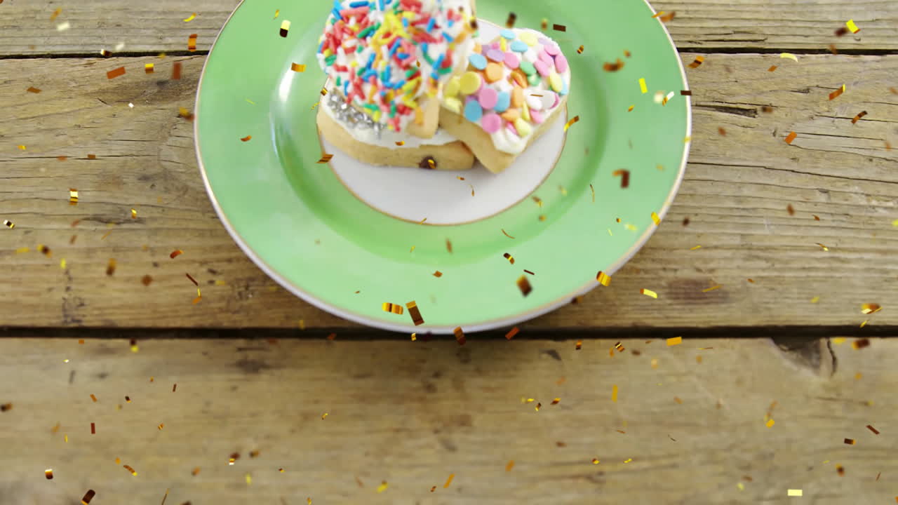 galletas en forma de corazón con salpicaduras coloridas en el plato, animación de confeti cayendo