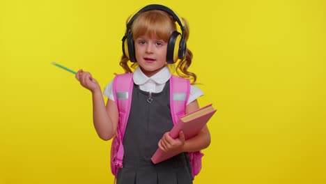 Pretty-smiling-girl-in-school-uniform-listening-music-via-headphones,-dancing-disco-fooling-around