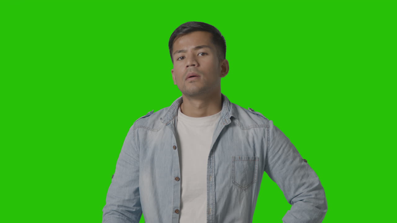 녹색 스크린 1에 대해 tv 채널을 통해 리모콘을 깜박이는 캐주얼한 옷을 입은 청년의 스튜디오 샷 1