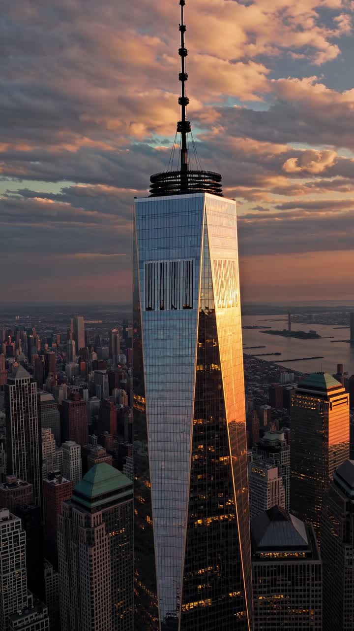 Aerial video captures a skyscraper at sunset, showcasing reflective glass and dramatic clouds