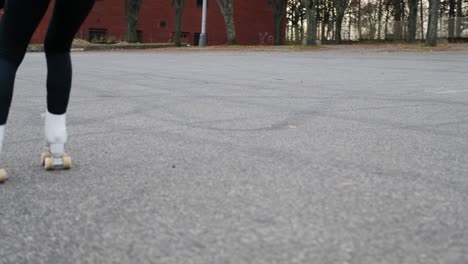 Zeitlupe-Eines-Rothaarigen-Mädchens,-Das-Rollschuhe-Auf-Asphalt-Fährt