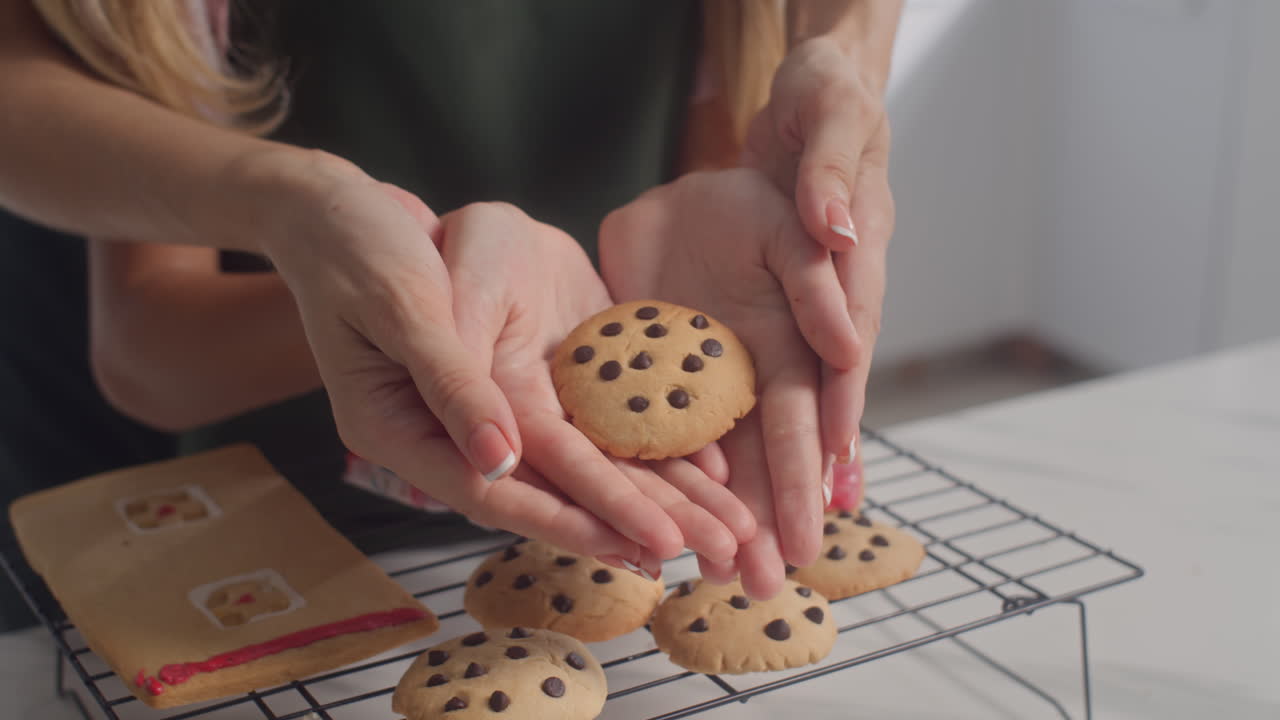 Daughter and Mother Holding Baked Christmas Cookies