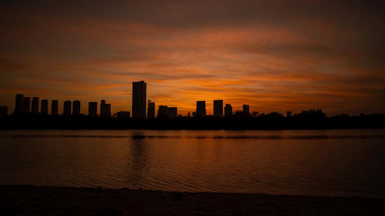 Horizonte urbano de Abu Dabi, Emiratos Árabes Unidos, desde el atardecer hasta el anochecer, visto desde la Isla Al Reem - time-lapse.