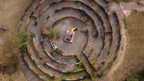 Luftaufnahme-Von-Oben-Nach-Unten,-Kreisende-Ansicht-Direkt-über-Dem-Künstlerischen,-Kreativen,-Leeren,-Farbenfrohen-Labyrinth-Mit-Holzstruktur-In-Der-Mitte