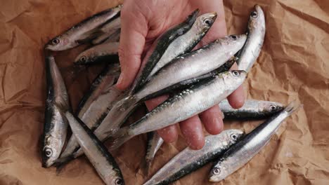 handful of sardines on brown paper