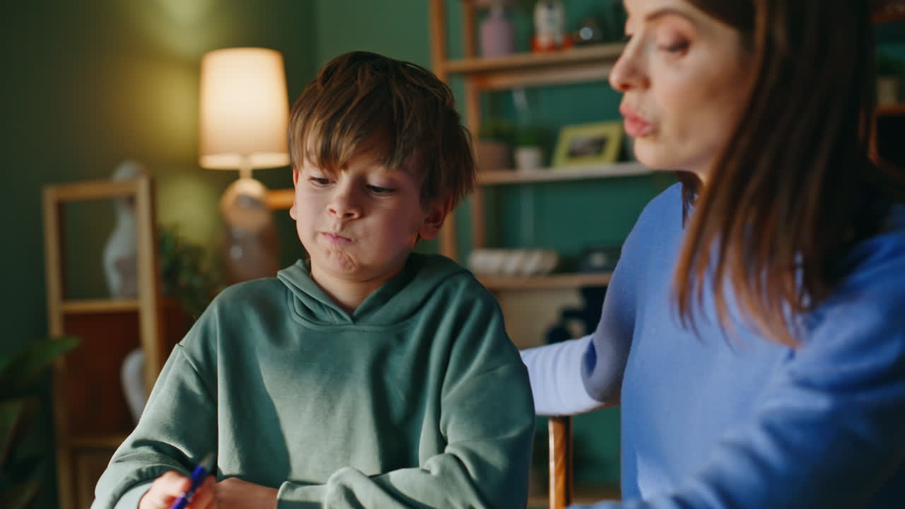 Primo piano di una madre che insegna al figlio intelligente, discutendo un esercizio scolastico e risolvendo un compito.