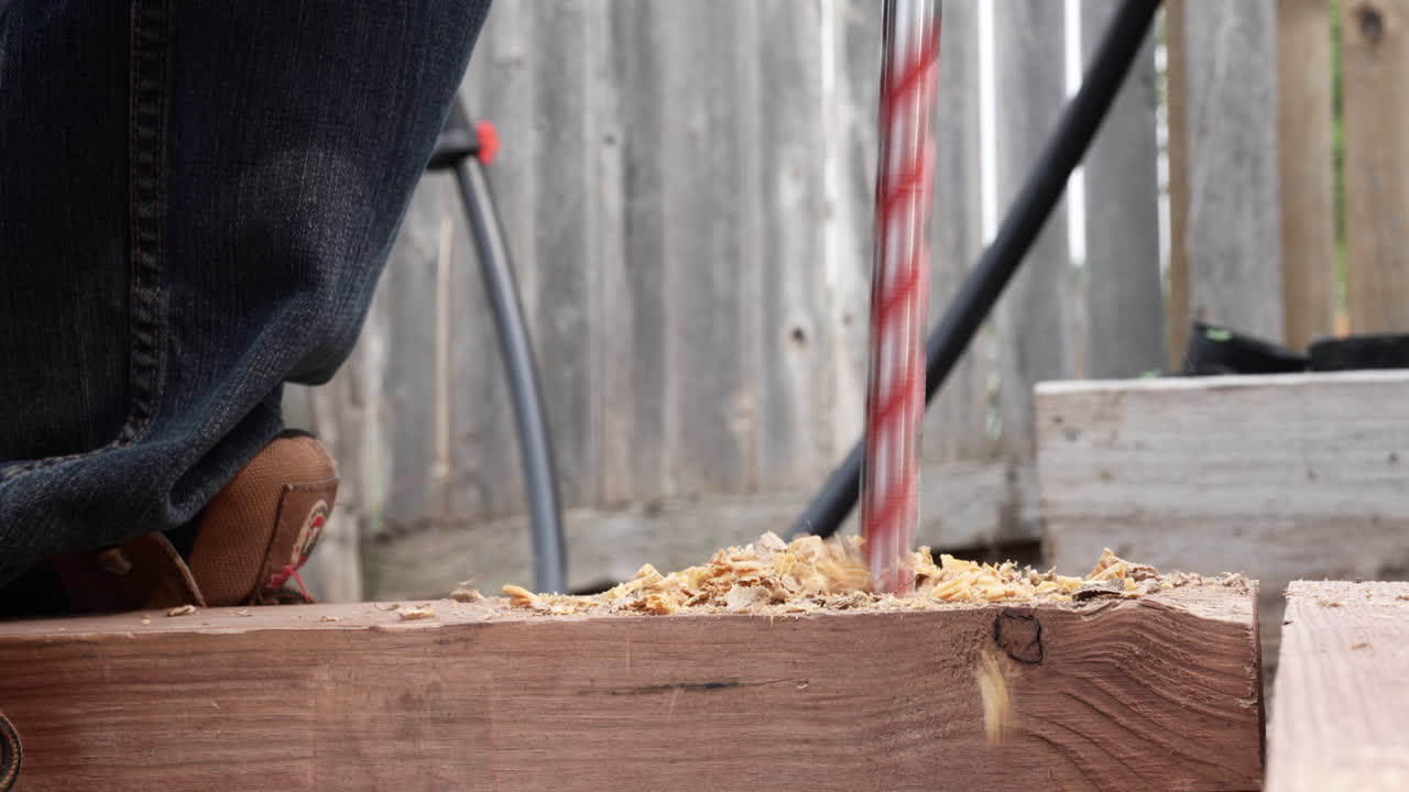 나무 판에 큰 구 ⁇ 을  ⁇ 는 금속 드릴 비트의 클로즈업