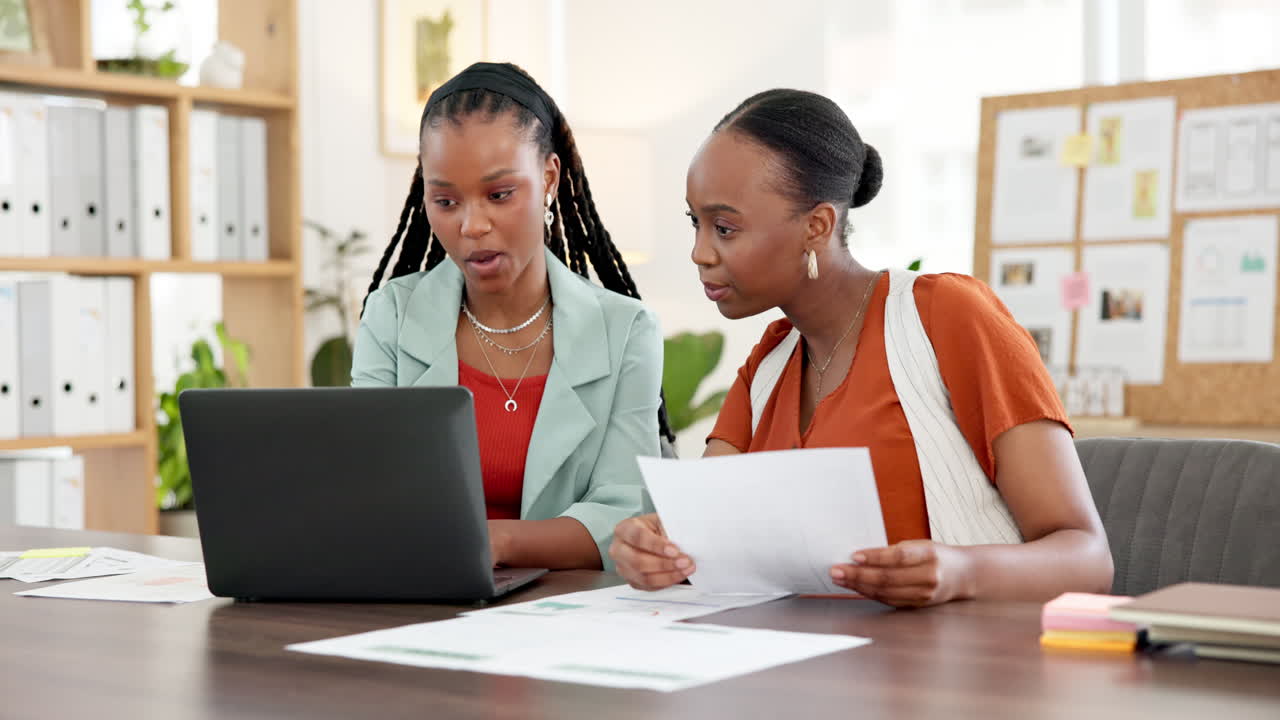 Due donne d'affari afroamericane che collaborano su un laptop in ufficio