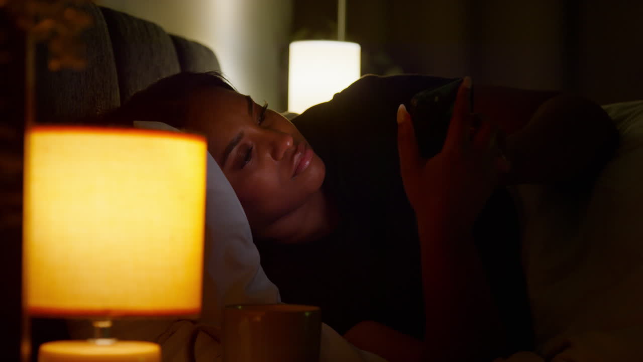mujer usando el teléfono en la cama por la noche