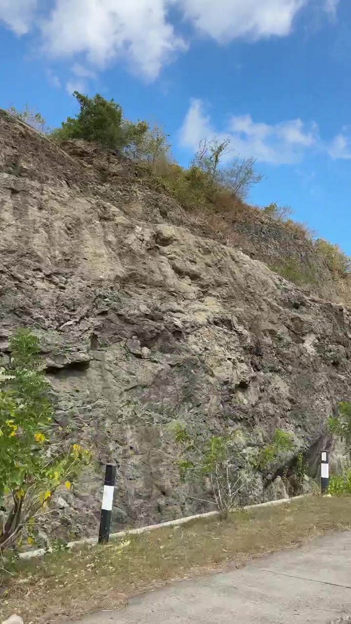 Panorámica a lo largo de una escarpada pared rocosa bajo un cielo azul claro
