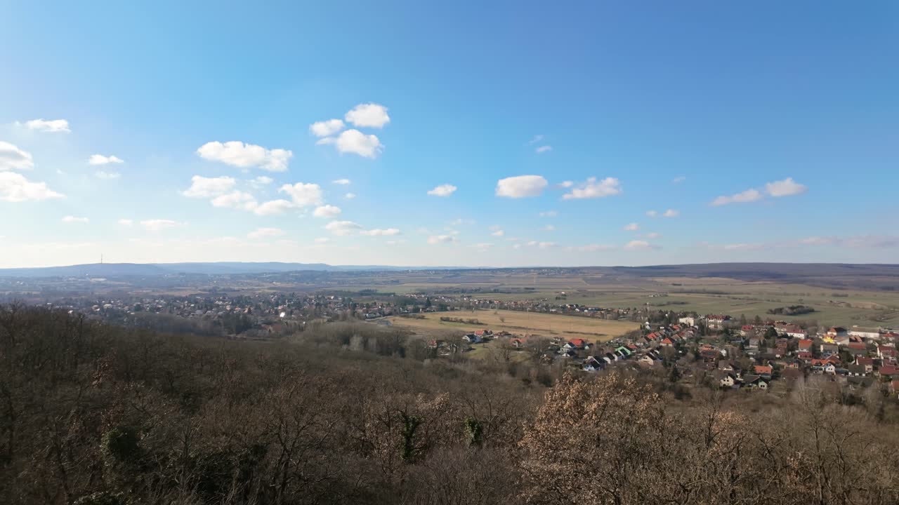 Wide aerial view of Sopron, Hungary, showing the landscape from Kecskehegyi Lookout with clear skies and green fields.